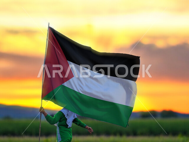 ذكرى احتفال اليوم الوطني الفلسطيني15نوفمبر، يوم بدينا1988م، حب الوطن والانتماء إليه، ولد عربي فلسطيني يرفع بيده علم الدولة الفلسطينية، المشاركة بالاعياد والمناسبات الوطنية، الركوض في احدى مناطق البلد