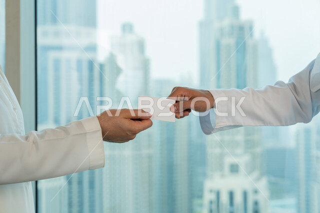 موك أب أبيض مستطيل فارغ، صداقات وبناء علاقات اجتماعية، صورة مقربة لايدي رجلي اعمال عربيين خليجيين اماراتيين يقومان بتبادل البطاقات التعريفية، الشراكة في الأعمال والمشاريع، مفهوم التعارف والتحاور