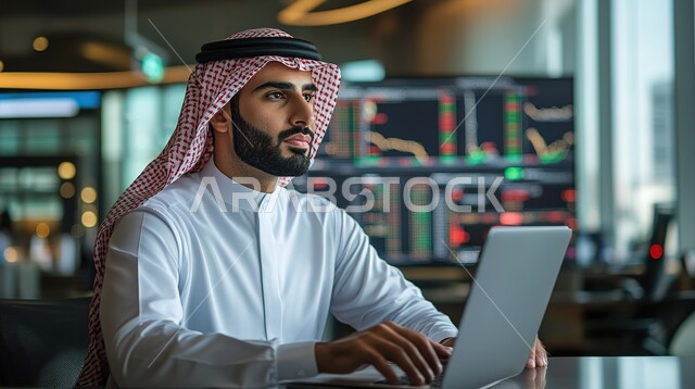 عرض المخططات البيانية المالية, إدارة شؤون الأعمال وتنظيمها عبر الاجهزة التقنية، دمج العمل مع التكنولوجيا، مهن ووظائف مكتبية،رجل اعمال عربي خليجي سعودي يرتدي الزي التقليدي والشماغ  يعمل على الحاسوب المحمول, العمل في المجال الاقتصادي