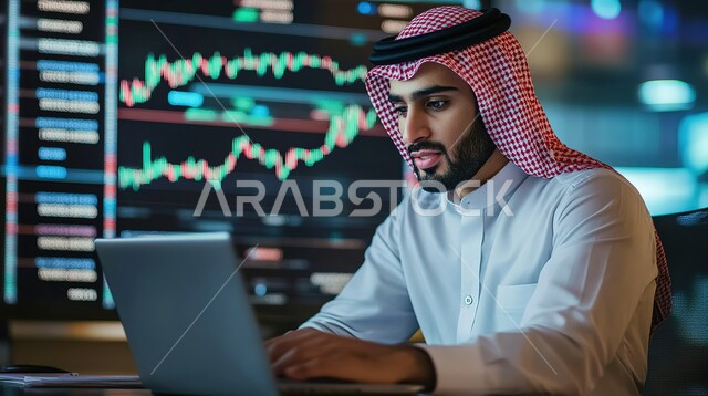 عرض المخططات البيانية المالية, إدارة شؤون الأعمال وتنظيمها عبر الاجهزة التقنية، دمج العمل مع التكنولوجيا، مهن ووظائف مكتبية،رجل اعمال عربي خليجي سعودي يرتدي الزي التقليدي والشماغ  يعمل على الحاسوب المحمول, العمل في المجال الاقتصادي