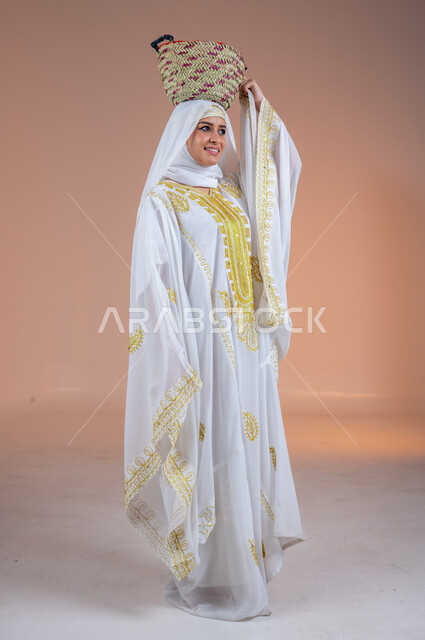 ارتداء أزياء المنطقة الشرقية في المناسبات الوطنية، مهن وحرف يدوية شعبية قديمة، يوم بدينا1727م، بورتريه لإمرأة عربية خليجية سعودية مبتسمة ترتدي الشيلة والنشل تضع على رأسها سلة قش، ذكرى تأسيس الدولة السعودية الأولى في 22 فبراير، صورة لكامل الجسم، خلفية ملونة