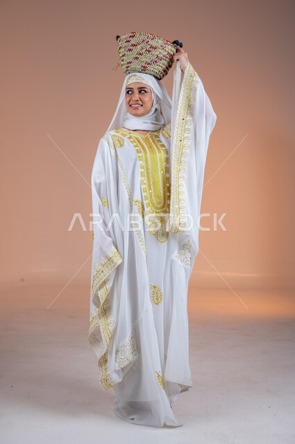 ارتداء أزياء المنطقة الشرقية في المناسبات الوطنية، مهن وحرف يدوية شعبية قديمة، يوم بدينا1727م، بورتريه لإمرأة عربية خليجية سعودية مبتسمة ترتدي الشيلة والنشل تضع على رأسها سلة قش، ذكرى تأسيس الدولة السعودية الأولى في 22 فبراير، صورة لكامل الجسم، خلفية ملونة