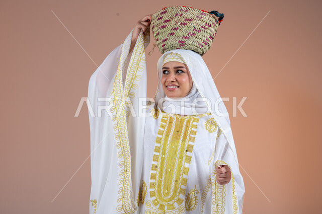تعابير الفخر والاعتزاز، ارتداء أزياء المنطقة الشرقية في المناسبات الوطنية، مهن وحرف يدوية شعبية قديمة، يوم بدينا1727م، بورتريه لإمرأة عربية خليجية سعودية مبتسمة ترتدي الشيلة والنشل تضع على رأسها سلة قش، ذكرى تأسيس الدولة السعودية الأولى في 22 فبراير، خلفية بنية