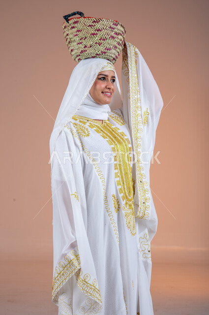 تعابير الفخر والاعتزاز، ارتداء أزياء المنطقة الشرقية في المناسبات الوطنية، مهن وحرف يدوية شعبية قديمة، يوم بدينا1727م، بورتريه لإمرأة عربية خليجية سعودية مبتسمة ترتدي الشيلة والنشل تضع على رأسها سلة قش، ذكرى تأسيس الدولة السعودية الأولى في 22 فبراير، خلفية بنية