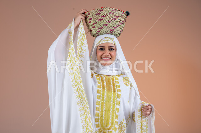 النظر الى الكاميرا بتعابير الفخر والاعتزاز،مهن وحرف يدوية شعبية قديمة، ارتداء أزياء المنطقة الشرقية، يوم بدينا1727م، بورتريه لإمرأة عربية خليجية سعودية مبتسمة ترتدي الشيلة والنشل تضع على رأسها سلة قش، ذكرى تأسيس الدولة السعودية الأولى في 22 فبراير، خلفية ملونة