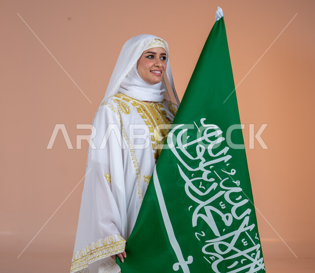 يوم بدينا 1727 م، ارتداء أزياء المنطقة الشرقية، بورتريه لإمرأة عربية خليجية سعودية مبتسمة ترتدي الشيلة والنشل تحمل بيدها علم المملكة، ذكرى تأسيس الدولة السعودية الأولى، يوم العلم السعودي11 مارس، الاحتفال بالمناسبات والأعياد الوطنية الشعبية، خلفية بنية