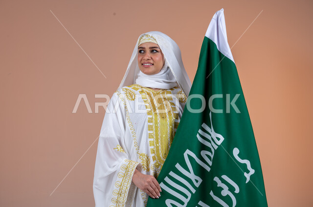 يوم العلم السعودي11 مارس، يوم بدينا 1727 م، ارتداء أزياء المنطقة الشرقية، بورتريه لإمرأة عربية خليجية سعودية مبتسمة ترتدي الشيلة والنشل تحمل بيدها علم يوم التأسيس، ذكرى تأسيس الدولة السعودية الأولى، الاحتفال بالمناسبات والأعياد الوطنية الشعبية، خلفية بنية