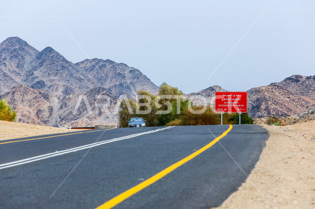 صورة للطريق السريع يمر بين الكثبان الرملية في الصحراء ، الرمال الذهبية الناعمة في صحراء السعودية