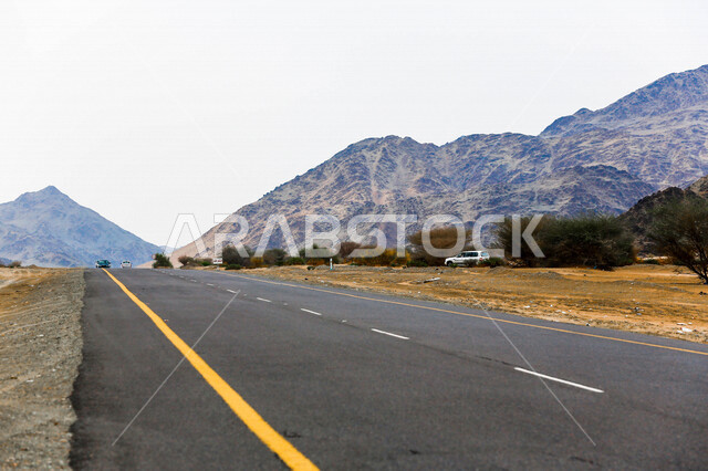 صورة للطريق السريع يمر بين الكثبان الرملية في الصحراء ، الرمال الذهبية الناعمة في صحراء السعودية