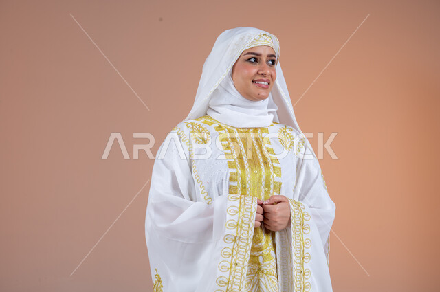 مفهوم الانوثة والاهتمام بالمظهر الخارجي، بورتريه لامرأة عربية خليجية سعودية مبتسمة ترتدي الشيلة والنشل تنظر الى مكان ما بتعابير الفخر والاعتزاز، يوم بدينا١٧٢٧م، ارتداء أزياء المنطقة الشرقية في المناسبات الوطنية، ذكرى تأسيس الدولة السعودية الأولى٢٢فبراير، خلفية بنية