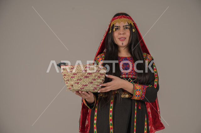  ذكرى تأسيس الدولة السعودية الأولى٢٢ فبراير، ارتداء أزياء المنطقة الوسطى, مهن وحرف يدوية شعبية، يوم بدينا ١٧٢٧م، بورتريه لإمرأه عربيه سعوديه خليجيه ترتدي الهامة والكرتة تمسك بيدها سلة قش، النظر الى الكاميرا بتعابير الفخر والاعتزاز، خلفيه رمادية