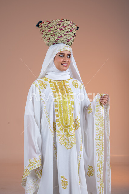 النظر الى مكان ما بتعابير الفخر، مهن وحرف يدوية شعبية قديمة، يوم بدينا 1727 م، ارتداء أزياء المنطقة الشرقية في المناسبات الوطنية، بورتريه لإمرأة عربية خليجية سعودية مبتسمة ترتدي الشيلة والنشل تضع على رأسها سلة قش، ذكرى تأسيس الدولة السعودية الأولى في 22 فبراير، خلفية بنية