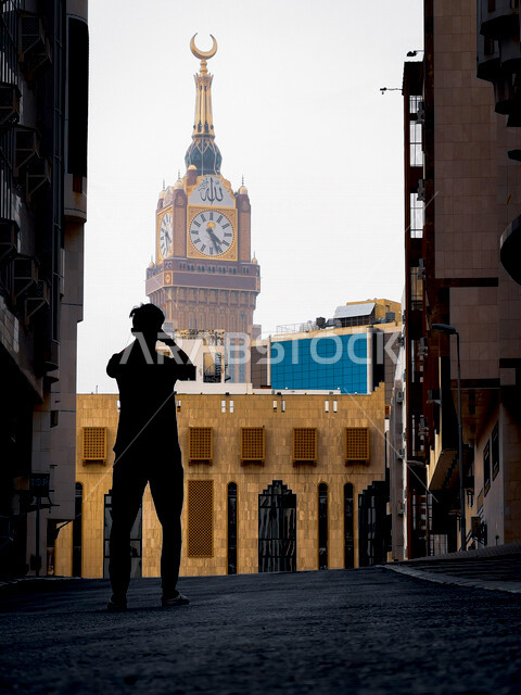 صورة مقربة لشاب عربي خليجي سعودي، ينظر الى برج الساعة، مكة المكرمة، برج الساعة بمكة المكرمة، السياحة الدينية في السعودية