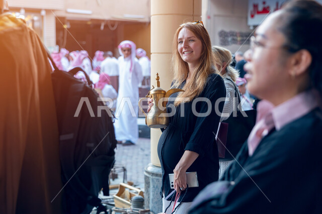 استقبال السياح الاجانب في الرياض في المملكة العربية السعودية، تقاليد وعادات شعبية في حسن الضيافة، تصوير مقرب لسواح اجانب يرتدون البشت السعودي المطرز، فتح ابواب السياحه السعودية، أماكن ومعالم سياحيه