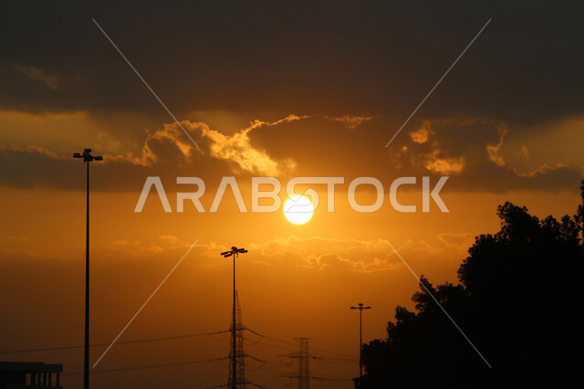 صورة ظلية للمباني اثناء غروب الشمس، منظر طبيعي خلاب اثناء الغروب، جمال المباني والاشجار مع غروب الشمس، جمال الشمس اثناء الغروب