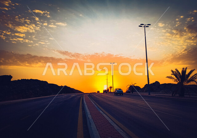 صورة ظلية لطريق اسفلتي اثناء غروب الشمس، منظر طبيعي خلاب اثناء الغروب، الشوارع والطرق والسيارات، جمال الشمس اثناء الغروب