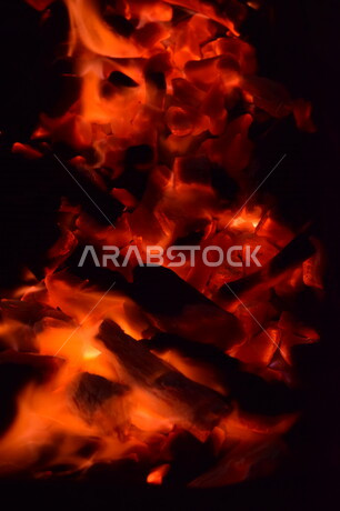 لهب النار على خلفية سوداء من الفن التجريدي ،  الشرارات الساخنة المحترقة ، صورة للنار المتوهجة ، خلفية جمر ملتهب أحمر