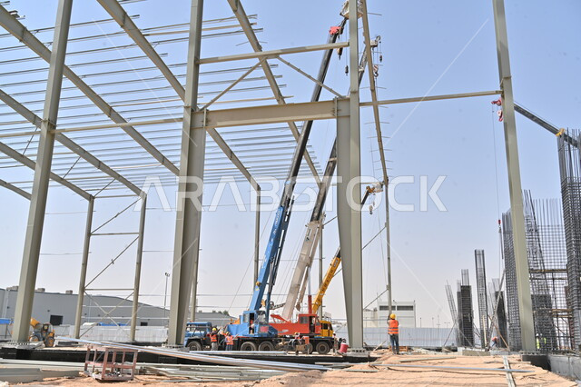  الجرافات والرافعات والسقالات العالية في موقع العمل, تنفيذ مخطط الإعمار وتشكيل الهيكل المعدني الأولي، أعمال البناء وصب الخرسانات ووضع الأساسات، الآلات والمعدات الثقيلة، مبنى قيد الانشاء في المملكة العربية السعودية, مفهوم الهندسة الانشائية والمعمارية