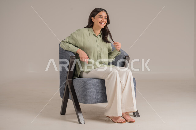 ايماءات تدل على الذهول لسماع خبر مفاجئ، الصدمة والتعجب من حصول أمر ما، بورتريه مقرب لامرأة عربية خليجية سعودية ترتدي الزي الكاجوال  تضع يديها على وجهها وتنظر إلى الكاميرا بتعابير الدهشة والخوف، خلفية بيج