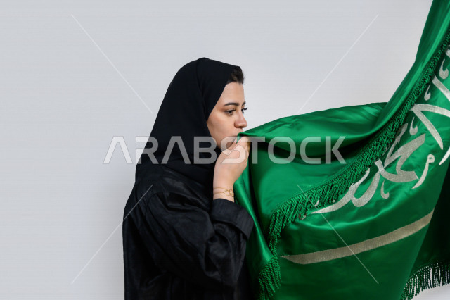 بورتريه لسيدة عربية خليجية سعودية تحمل بين يديها المملكة العربية السعودية و تقوم بتقبيله ، اليوم الوطني السعودي ، الإحتفال بالعيد الوطني ، خلفية بيضاء