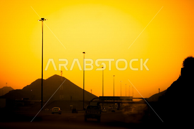 صورة توضيحية للطرق ووسائل المواصلات اثناء غروب الشمس، منظر طبيعي خلاب اثناء الغروب، السيارات والطرق والشوارع، جمال السماء مع غروب الشمس
