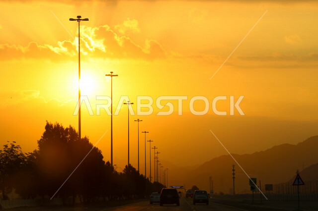 صورة توضيحية للطرق ووسائل المواصلات اثناء غروب الشمس، منظر طبيعي خلاب اثناء الغروب، السيارات والطرق والشوارع