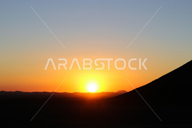 صورة ظلية لجبل في الصحراء اثناء غروب الشمس، منظر طبيعي خلاب اثناء الغروب، جمال الطبيعة الجبلية، غروب الشمس