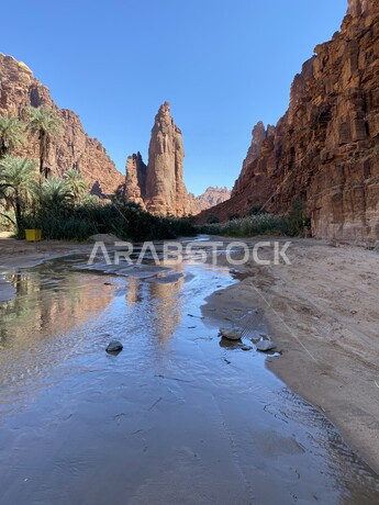 صورة لوادي و جبال الديسة الساحرة في منطقة تبوك ، جريان الماء في الوادي ، روعة و جمال الطبيعة الخلابة في السعودية
