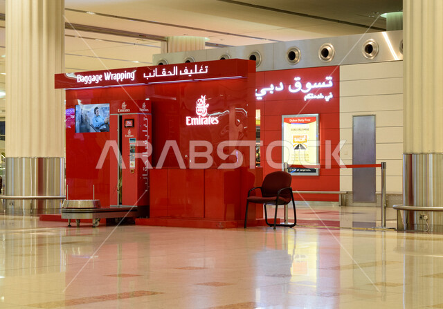 صورة مقربة لماكينة تغليف الحقائب في مطار دبي الدولي بالإمارات العربية المتحدة، خدمة تغليف الأمتعة، تسوق دبي في خدمتكم، مطار دبي الدولي 
