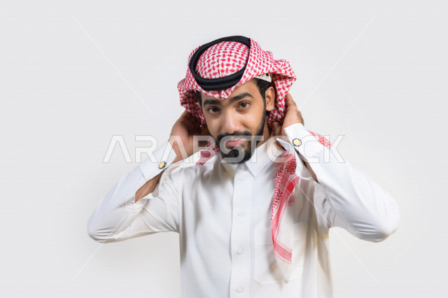 بورتريه لرجل عربي خليجي سعودي يرتدي الزي السعودي التقليدي بإيماءات تدل على السعادة ، خلفية بيضاء