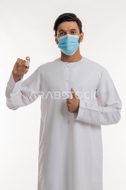 علامة الجودة والامتياز، تلقي التطعيم ضد فايروس كورونا، بورتريه لرجل عربي خليجي إماراتي يرتدي الكندورة والكمامة يحمل بيده جرعة لقاح كوفيد - 19 يرفع إبهامه للأعلى، اتباع إجراءات وزارة الصحة، نشر الوعي الصحي للحد من انتشار الأمراض، خلفية بيضاء