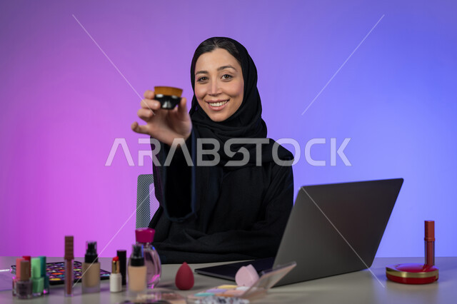 التسويق لمنتجات و مساحيق التجميل عبر الانترنت، متجر بيع مستحضرات التجميل و المكياج، مفهوم الإهتمام بالجمال و البشرة، بورتريه لسيدة عربية خليجية اماراتية محجبة تروج لإعلان تجاري لبيع أدوات تجميل البشرة، خبيرة مستحضرات تجميل سعودية، خلفية ملونة