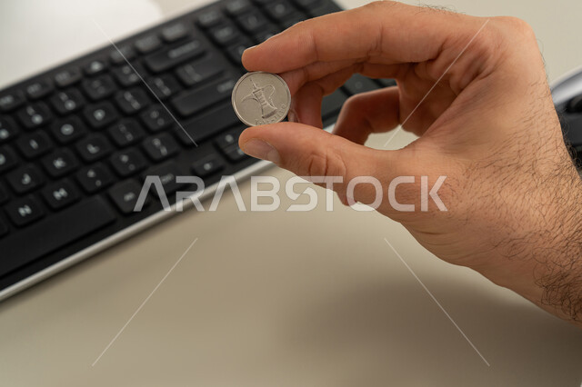 عرض الإصدار الجديد للنقود الاماراتية، العملة المتداولة في أسواق الامارات العربية المتحدة،  بورتريه لرجل عربي خليجي اماراتي يرتدي الكندورة والغترة يمسك بيده الفلوس، الأعمال الاقتصادية المالية، محاولة إدارة المصروف المنزلي بتدبر، السعي نحو الادخار، خلفية بيضاء