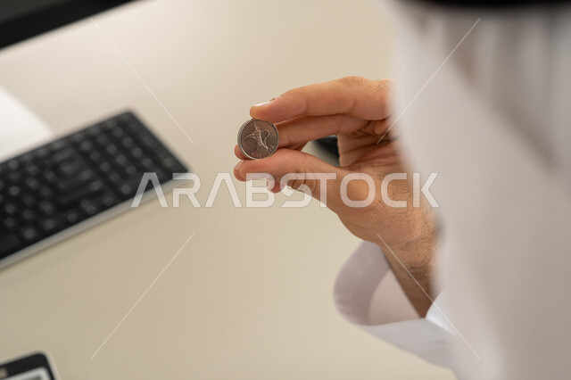 عرض الإصدار الجديد للنقود الاماراتية، العملة المتداولة في أسواق الامارات العربية المتحدة،  بورتريه لرجل عربي خليجي اماراتي يرتدي الكندورة والغترة يمسك بيده الفلوس، الأعمال الاقتصادية المالية، محاولة إدارة المصروف المنزلي بتدبر، السعي نحو الادخار، خلفية بيضاء