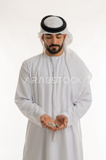 عرض الإصدار الجديد للنقود الاماراتية، العملة المتداولة في أسواق الامارات العربية المتحدة،  بورتريه لرجل عربي خليجي اماراتي يرتدي الكندورة والغترة يمسك بيده الفلوس، الأعمال الاقتصادية المالية، محاولة إدارة المصروف المنزلي بتدبر، السعي نحو الادخار، خلفية بيضاء