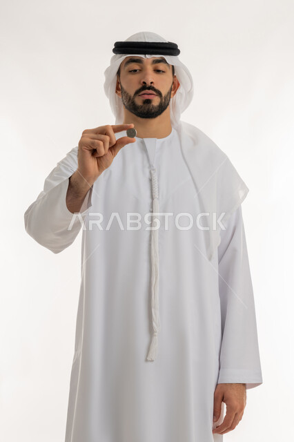 عرض الإصدار الجديد للنقود الاماراتية، العملة المتداولة في أسواق الامارات العربية المتحدة،  بورتريه لرجل عربي خليجي اماراتي يرتدي الكندورة والغترة يمسك بيده الفلوس، الأعمال الاقتصادية المالية، محاولة إدارة المصروف المنزلي بتدبر، السعي نحو الادخار، خلفية بيضاء