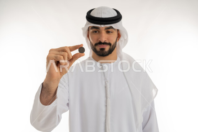 عرض الإصدار الجديد للنقود الاماراتية، العملة المتداولة في أسواق الامارات العربية المتحدة،  بورتريه لرجل عربي خليجي اماراتي يرتدي الكندورة والغترة يمسك بيده الفلوس، الأعمال الاقتصادية المالية، محاولة إدارة المصروف المنزلي بتدبر، السعي نحو الادخار، خلفية بيضاء