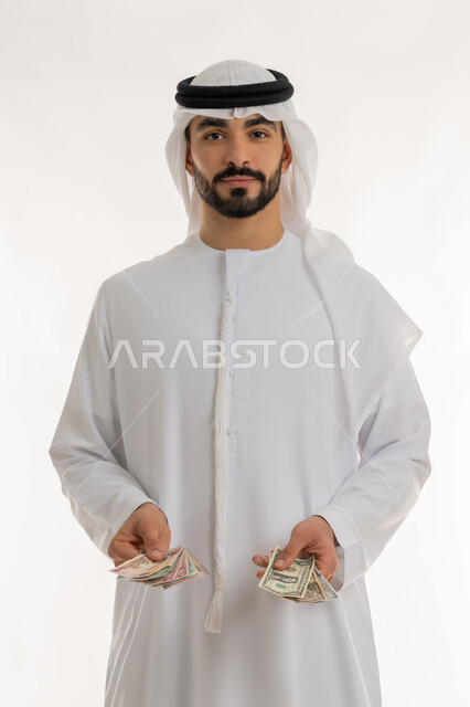 Displaying the new issue of UAE currency, the currency in circulation in the UAE markets, a portrait of an Emirati Gulf Arab man wearing a kandura and a ghutra holding money in his hand, financial economics, trying to manage household expenses wisely, striving to save, white background