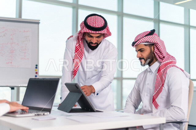 اجتماع مجموعة من رجال الاعمال الخليجيين السعوديين داخل الشركة ، استخدام جهاز اللابتوب والتابلت اثناء الاجتماع ، الاستماع الى قائد الفريق ، مناقشة اهداف وسياسة الشركة ، شرح استراتيجية العمل ، مناقشة مشروع، ورشة عمل، تدريب وتطوير الموظفين