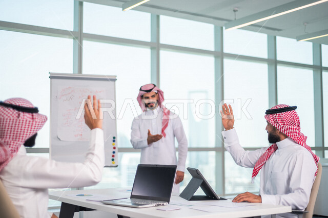 اجتماع مجموعة من رجال الاعمال الخليجيين السعوديين داخل الشركة ، استخدام جهاز اللابتوب والتابلت اثناء الاجتماع ، الاستماع الى قائد الفريق ، مناقشة اهداف وسياسة الشركة ، شرح استراتيجية العمل ، مناقشة مشروع، ورشة عمل، تدريب وتطوير الموظفين