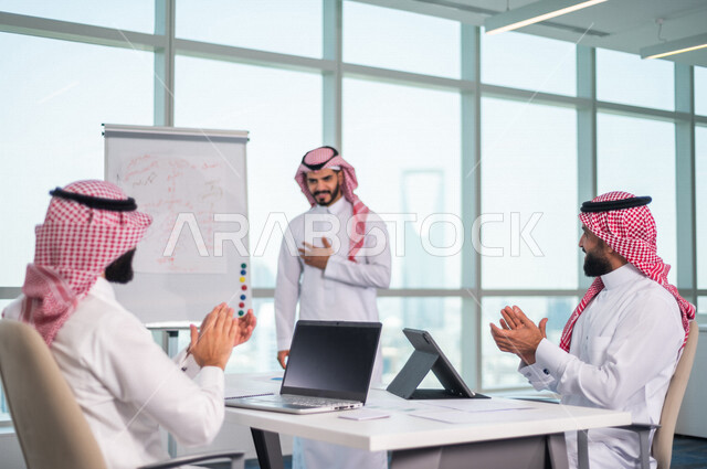 اجتماع مجموعة من رجال الاعمال الخليجيين السعوديين داخل الشركة ، استخدام جهاز اللابتوب والتابلت اثناء الاجتماع ، الاستماع الى قائد الفريق ، مناقشة اهداف وسياسة الشركة ، شرح استراتيجية العمل ، مناقشة مشروع، ورشة عمل، تدريب وتطوير الموظفين