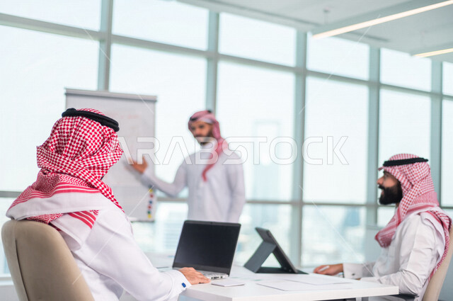 اجتماع مجموعة من رجال الاعمال الخليجيين السعوديين داخل الشركة ، استخدام جهاز اللابتوب والتابلت اثناء الاجتماع ، الاستماع الى قائد الفريق ، مناقشة اهداف وسياسة الشركة ، شرح استراتيجية العمل ، مناقشة مشروع، ورشة عمل، تدريب وتطوير الموظفين