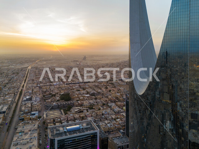 الفن الهندسي المعماري للأبراج وناطحات السحاب في العاصمة، صورة مقربة لانعكاس المباني السكنية والتجارية على برج المملكة في مدينة الرياض وقت غروب الشمس، تطور وتنمية العمران في المملكة العربية السعودية، معالم سياحية مشهورة