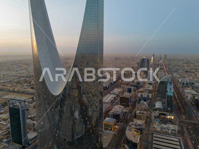 الفن الهندسي المعماري للأبراج وناطحات السحاب في العاصمة، صورة مقربة لانعكاس المباني السكنية والتجارية على برج المملكة في مدينة الرياض في النهار، تطور وتنمية العمران في المملكة العربية السعودية، معالم سياحية مشهورة