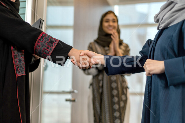 سيدتان عربيتان خليجيتان تتصافحان داخل الشركة ، اتفاق عمل بين سيدات الاعمال ، صفقة ناجحة ، تعاون تجاري ، عمل جماعي مشترك