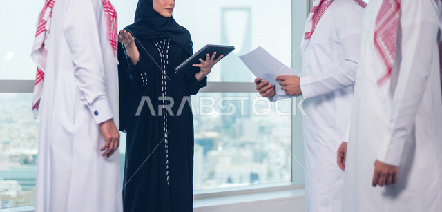مجموعة من الرجال الاعمال السعوديين داخل مقر الشركة ، مناقشة جدول الاعمال و المهام ، سكرتيرة عربية سعودية خليجية تعمل على تنظيم المهام و الاعمال و تدوين الملاحظات  عبر جهاز تقني، الوحدة والعمل الجماعي