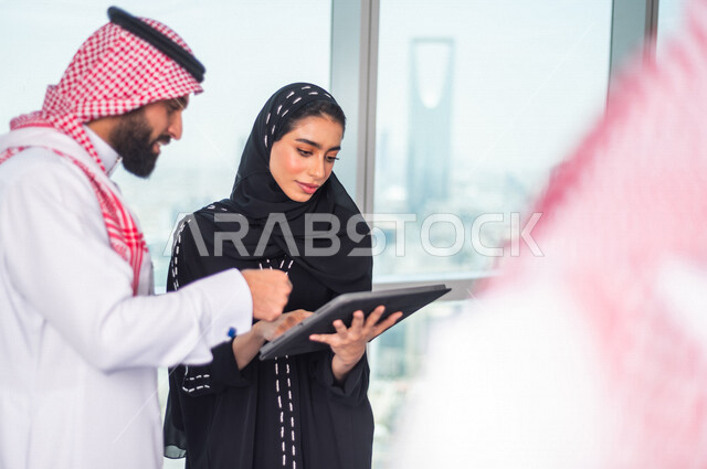 مجموعة من الرجال الاعمال السعوديين داخل مقر الشركة ، مناقشة جدول الاعمال و المهام ، سكرتيرة عربية سعودية خليجية تعمل على تنظيم المهام و الاعمال و تدوين الملاحظات  عبر جهاز تقني، الوحدة والعمل الجماعي