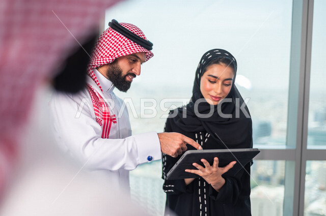 مجموعة من الرجال الاعمال السعوديين داخل مقر الشركة ، مناقشة جدول الاعمال و المهام ، سكرتيرة عربية سعودية خليجية تعمل على تنظيم المهام و الاعمال و تدوين الملاحظات  عبر جهاز تقني، الوحدة والعمل الجماعي