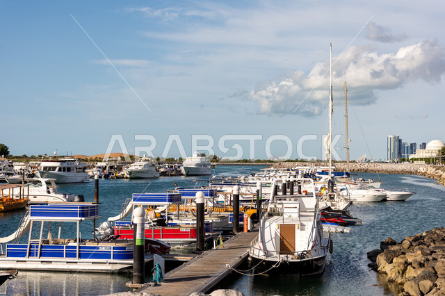 Summer entertainment activities, the waterfront on the Arabian Gulf coast, yachts and motor boats in the port during the day, distinguished marine transportation in Abu Dhabi, famous tourist places in the United Arab Emirates
