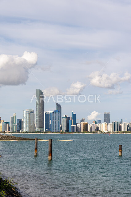 The development and urban progress of buildings and facilities in the UAE, the architectural art of towers and skyscrapers overlooking the sea, famous tourist attractions in the city of Abu Dhabi, places of attraction and attraction of tourists, the waterfront on the coast of the Arabian Gulf during the day